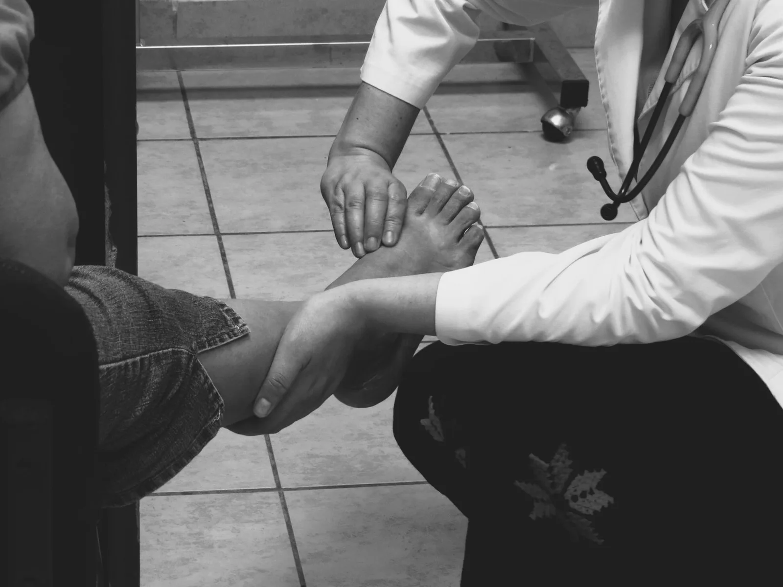Profesional evalúa el pie y la extremidad inferior de un paciente en consulta.