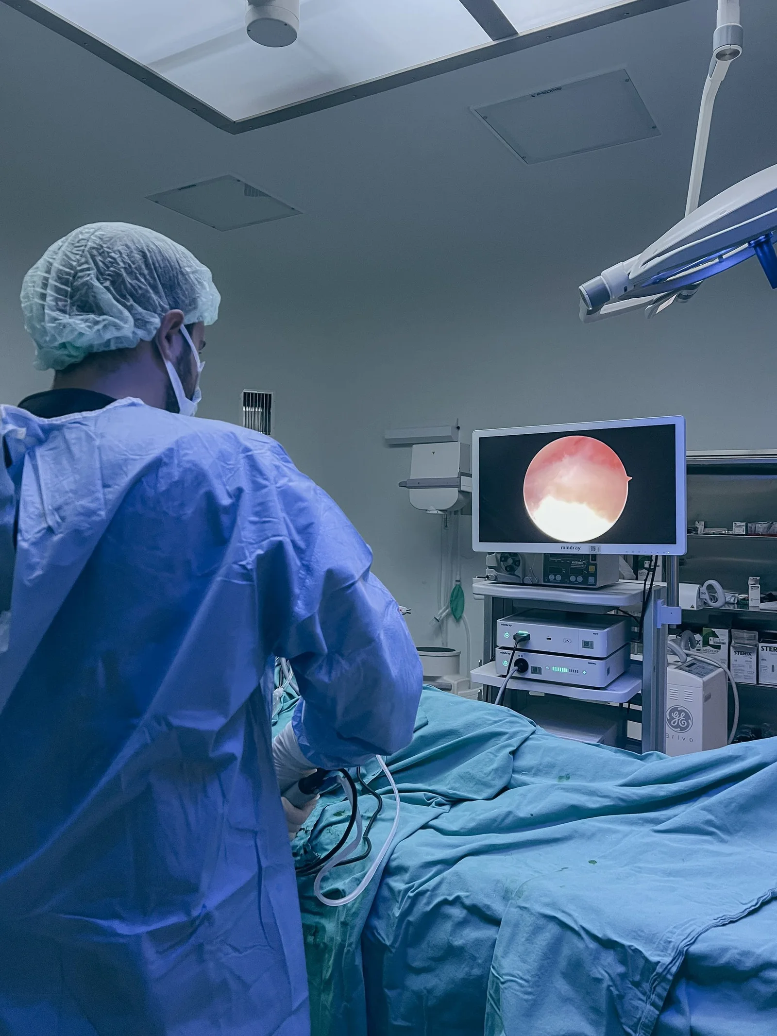 Equipo médico realiza un procedimiento endoscópico guiado por monitor.